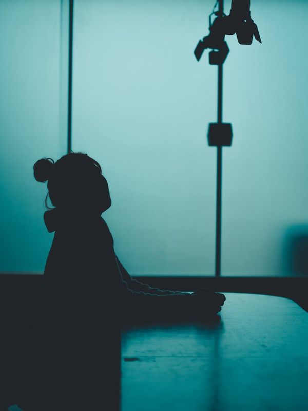 Silhouette of a woman in a meditative pose against a light blue background.